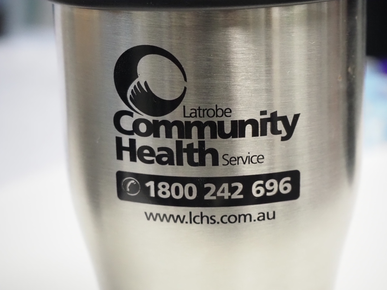 Metal tumbler featuring Latrobe Community Health Service logo, phone, and website.