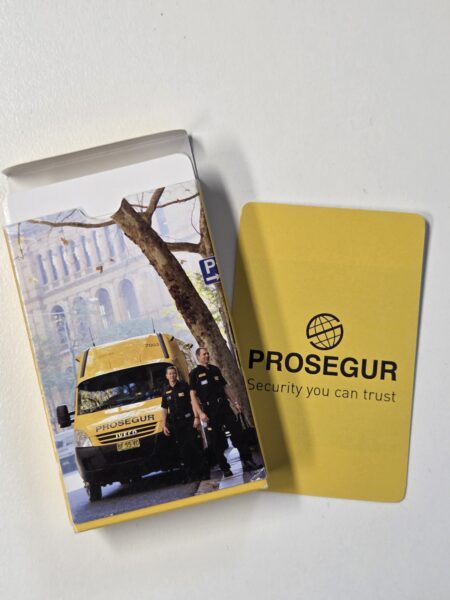 Yellow Prosegur card and box with image of security guards, van, and branded promotional items.