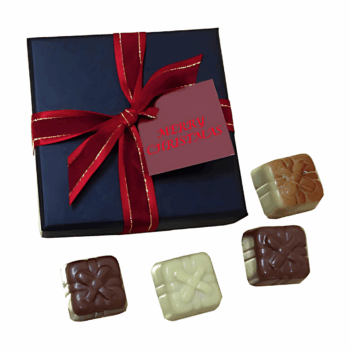 A Nearmap-themed gift box with a red ribbon and card, beside four assorted chocolates.