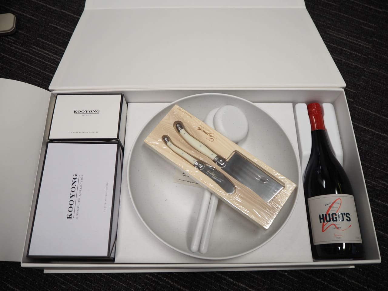 Gift box with wine, plate, cutlery, and chopsticks—stylish promotional products on display.