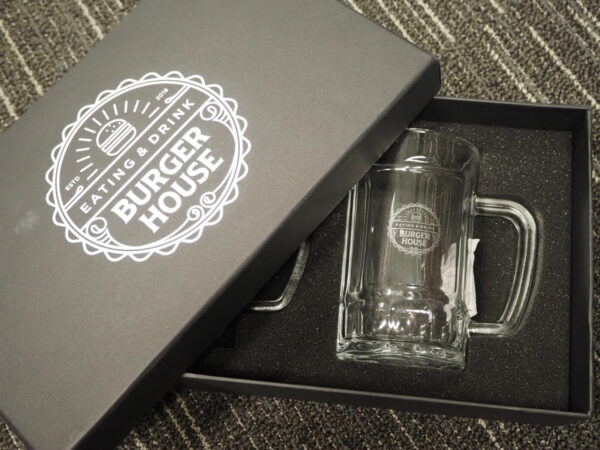 A clear glass mug in a black Burger House box—perfect for corporate gift box ideas.