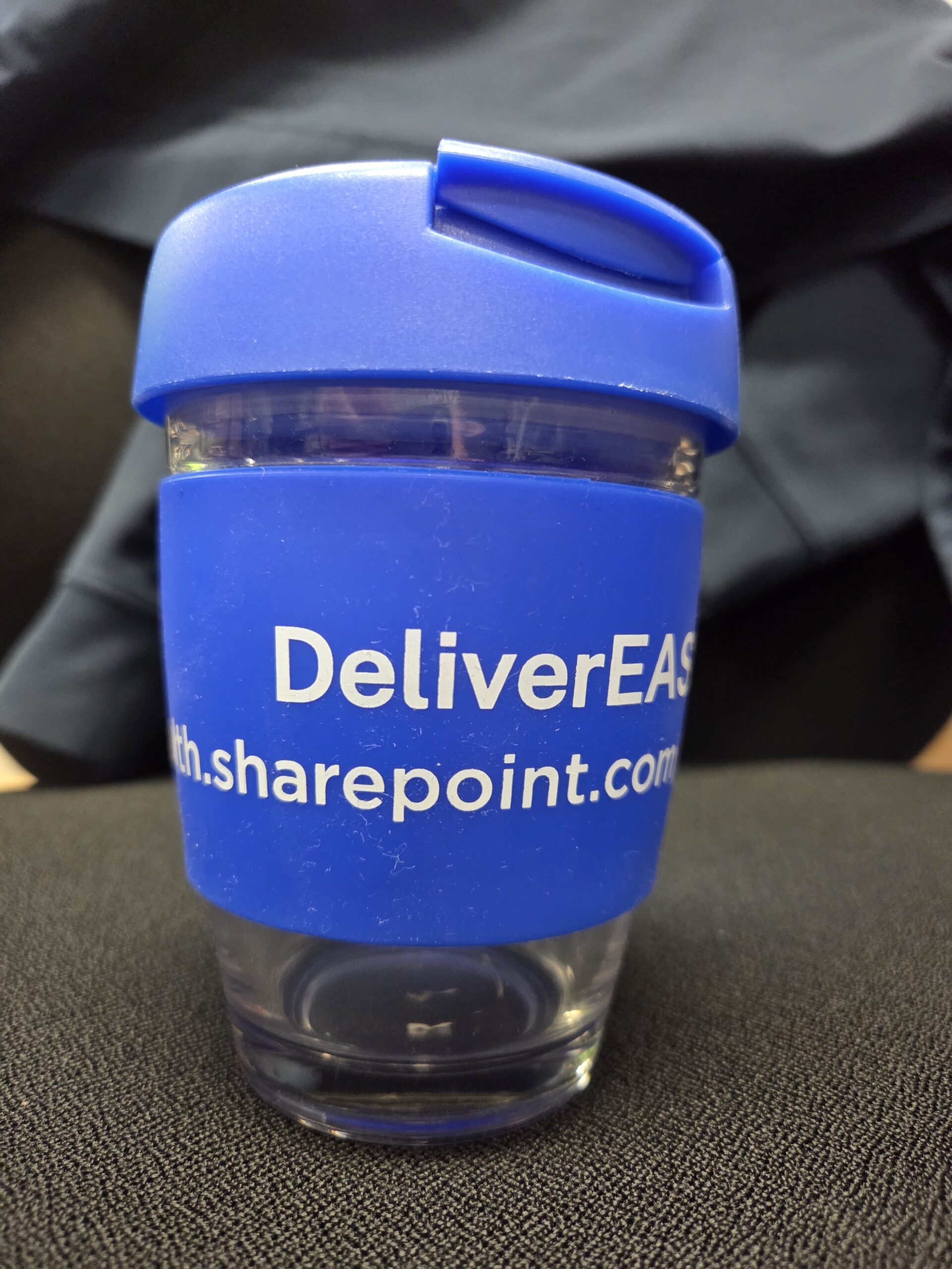 Blue reusable cup featuring DeliverEAS’s rebrand and part of a website URL.