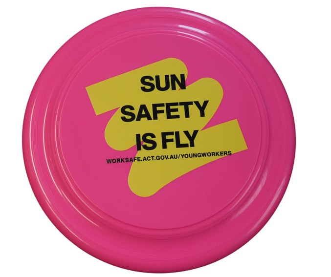 A pink frisbee—one of the funnest promotional items—with SUN SAFETY IS FLY on a yellow label.