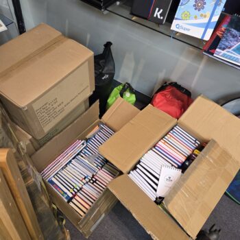 Open cardboard boxes filled with assorted notebooks, ready for placing an order.