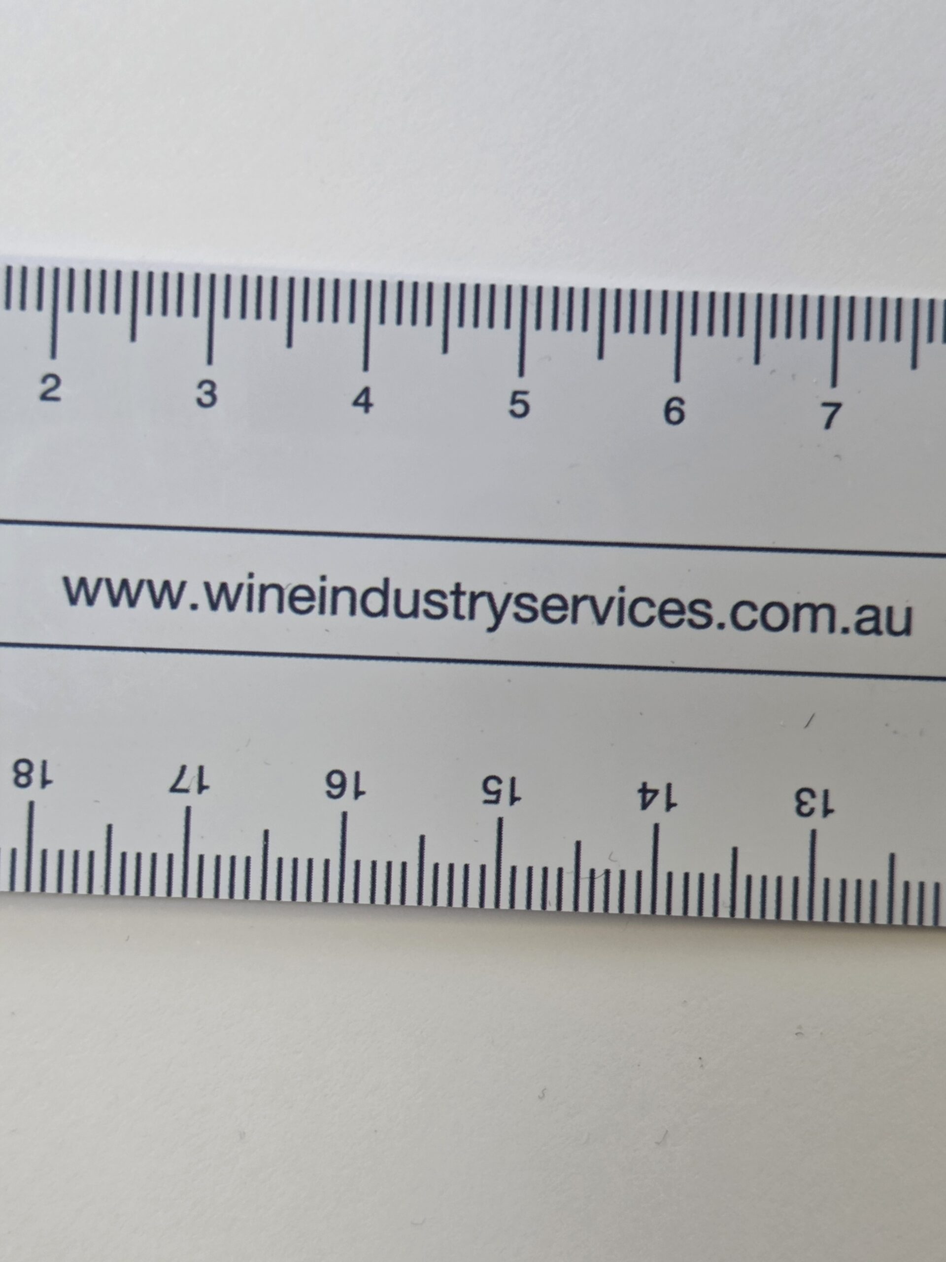 A close-up of a ruler featuring www.wineindustryservices.com.au, a wine industry service.