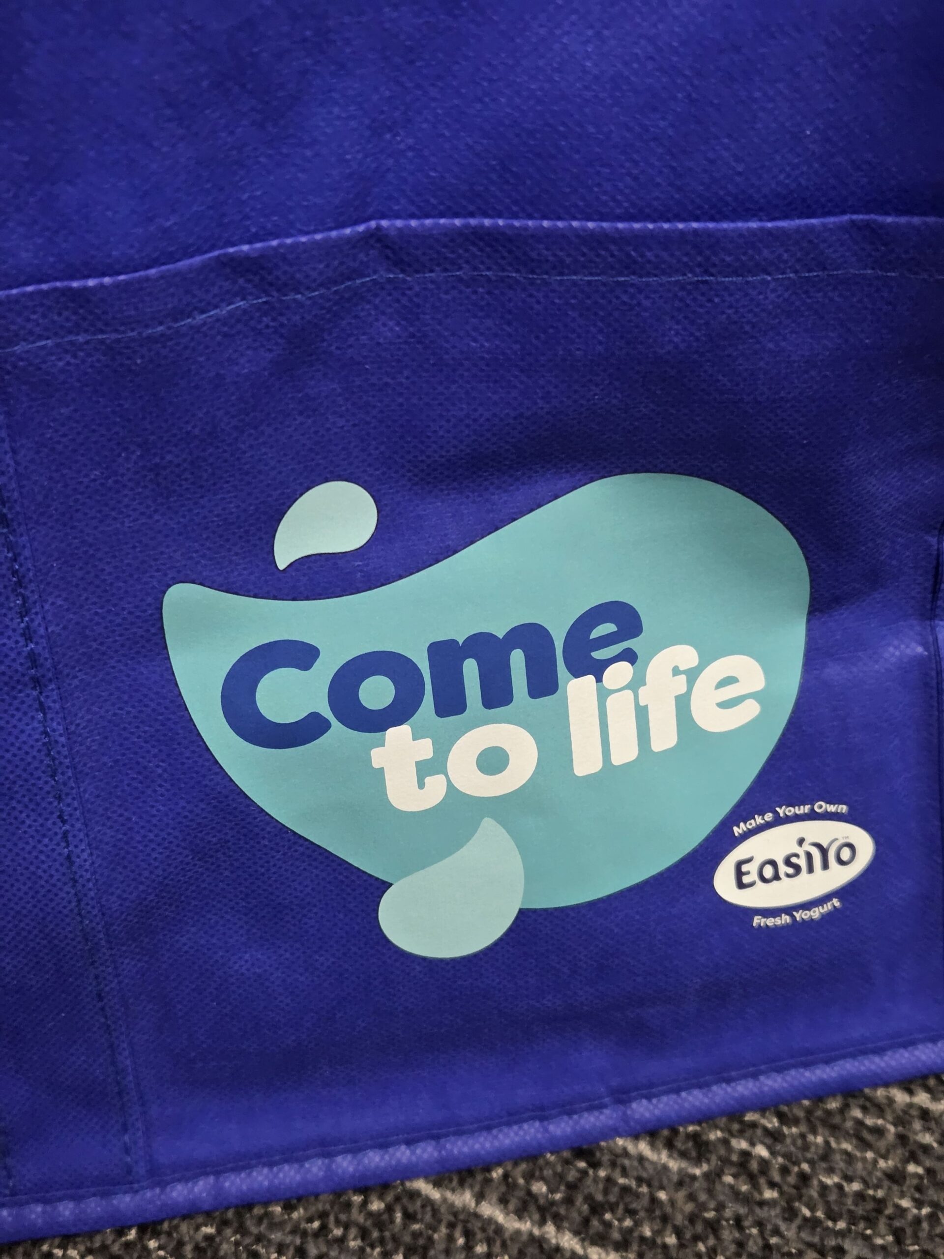 Blue tote bag with EasiYo and Come to life fresh yogurt logos printed on it.