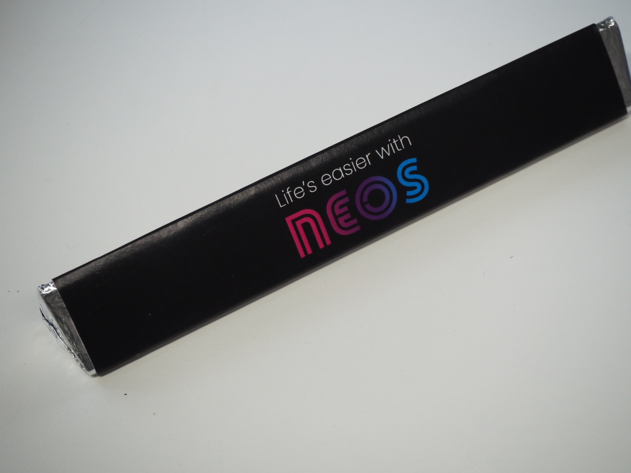 A black rectangular NEOS box with Lifes easier with NEOS in colorful letters for a Happy Client.