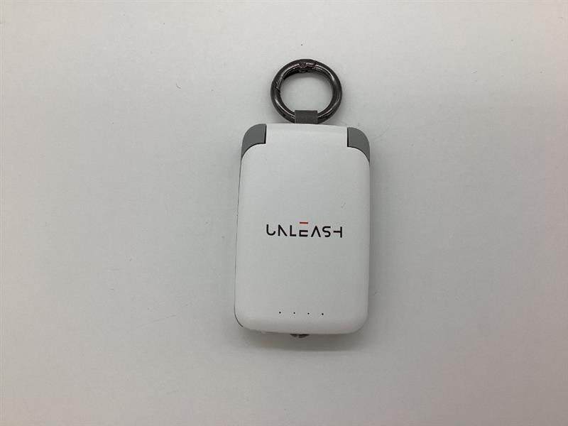 A white Unleash keychain device with a ring on a plain white background.