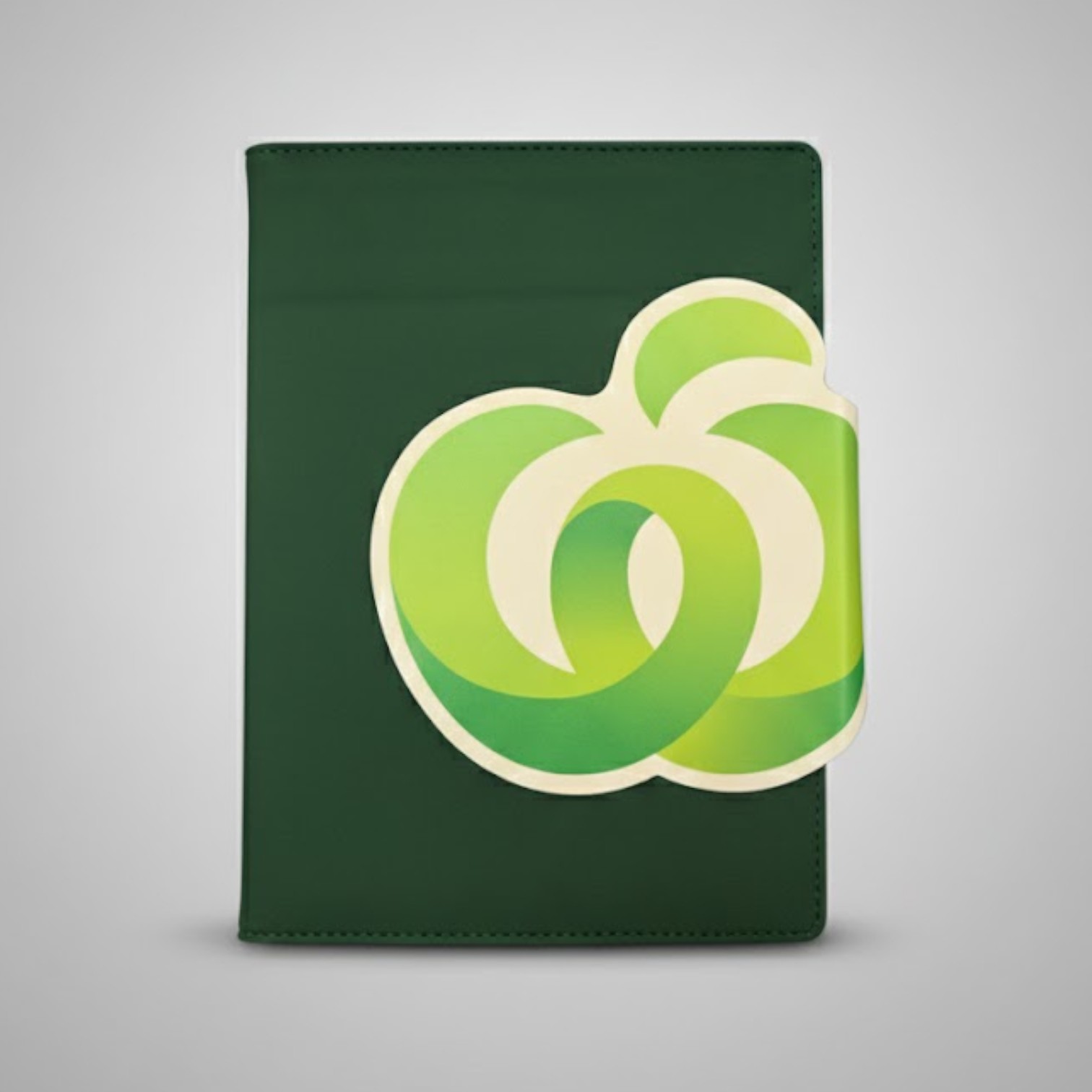 A green notebook featuring bold branding with a large abstract green and white logo on the cover.