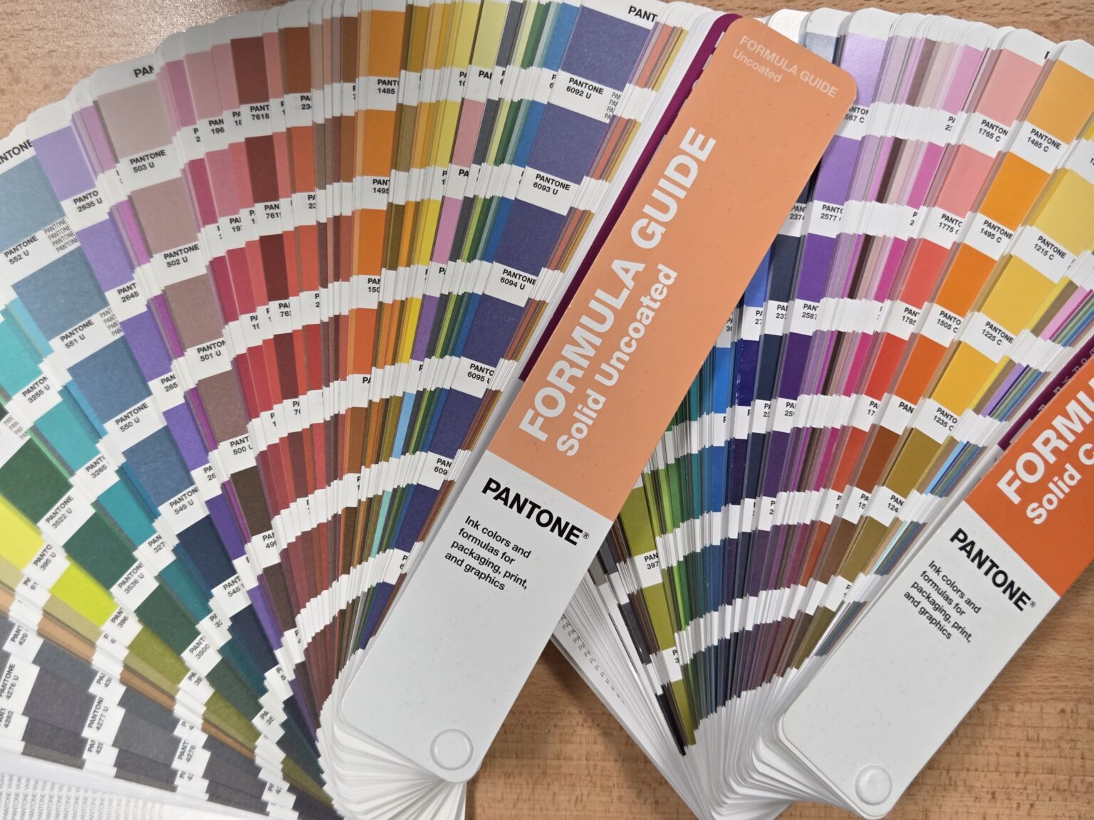 Pantone color swatch books fanned out in a showroom, displaying a wide range of colors.