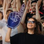 A woman holding a foam finger.