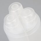Close-up of three clear plastic bottle caps against a plain, light gray background.