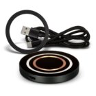 Black wireless charging pad with concentric circles and a braided USB-C charging cable.