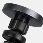 Close-up of a black wireless car charger with a blue indicator light.