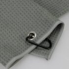 Close-up of grey textured fabric with a metal grommet and a black carabiner clip attached.