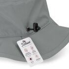 A gray Titleist hat with an adjustable drawcord and a product tag attached.