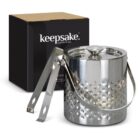 Stainless steel ice bucket with lid, tongs, and a carrying handle beside a black box.