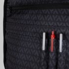 Close-up of backpack pockets holding two silver pens and one red pen.