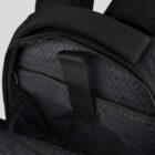 Open black backpack showing interior with a patterned lining and a black fabric strap.