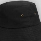 Close-up of a black bucket hat with two small metal eyelets on the side.