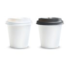 Two white takeaway coffee cups, one with a white lid and one with a black lid, on a white background.