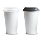 Two white disposable coffee cups, one with a white lid and one with a black lid.