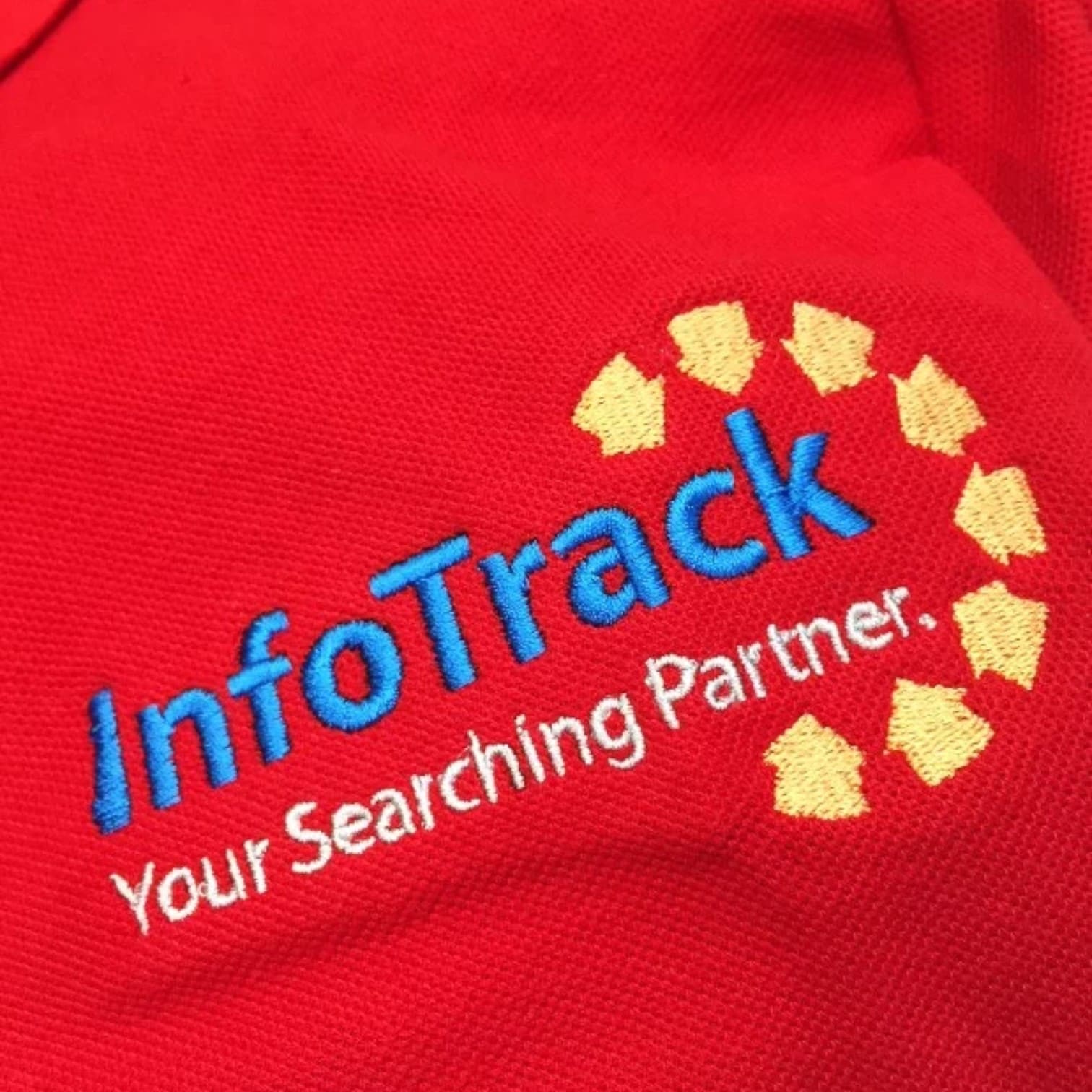 Red fabric with print colour accuracy, InfoTrack Your Searching Partner, and yellow arrow logo.