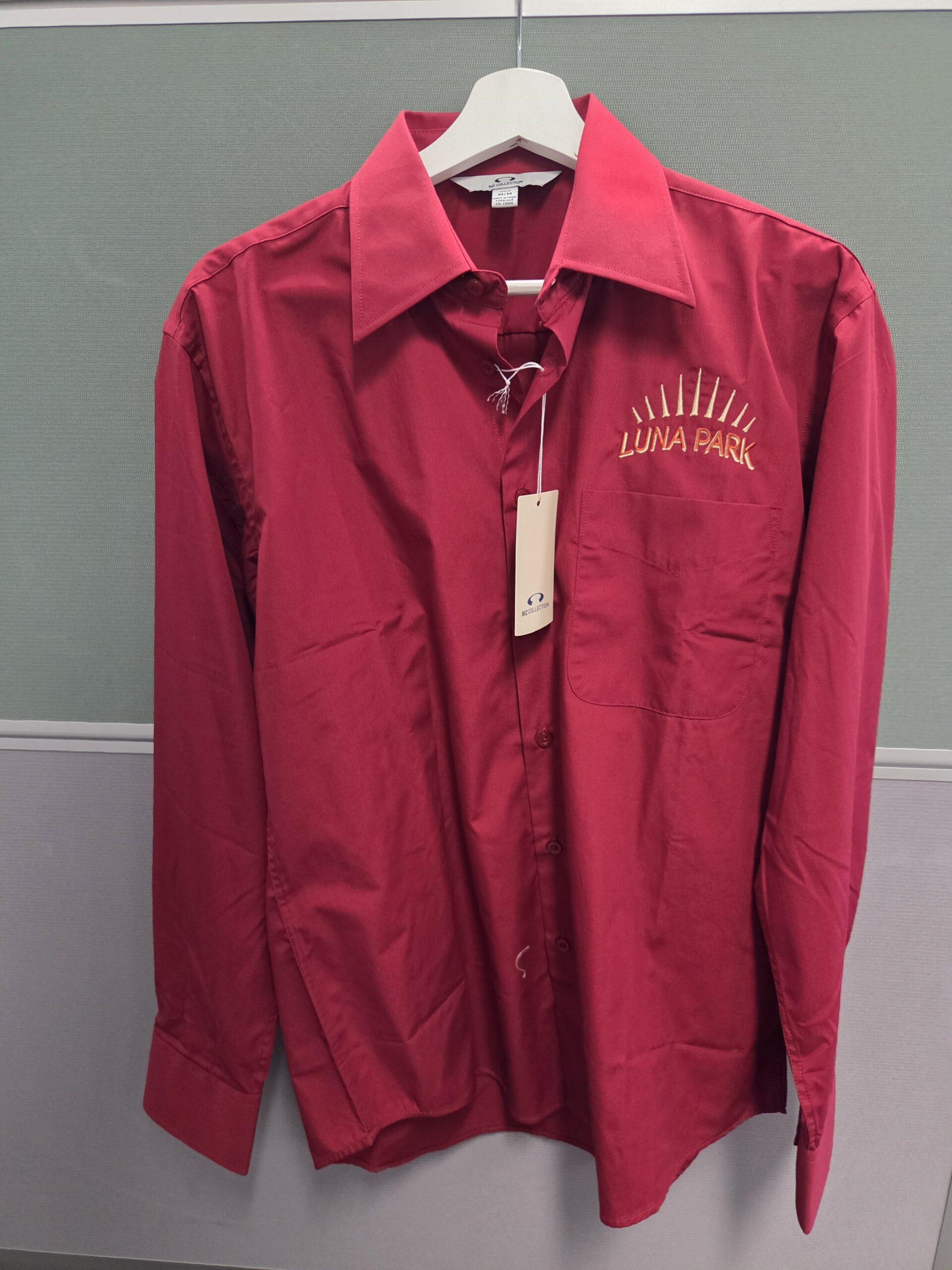 A red button-up shirt with LUNA PARK embroidery, showcasing embroidery vs screen printing.