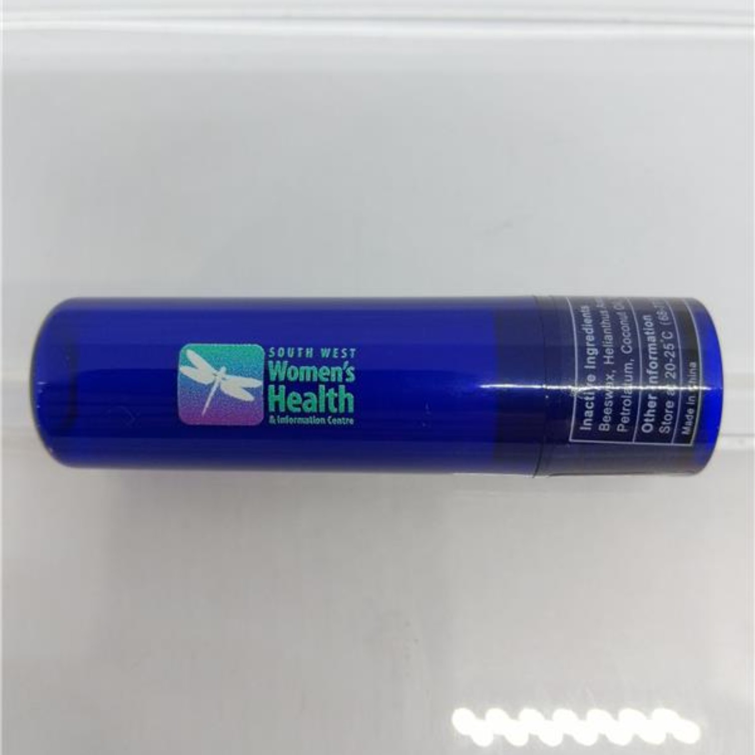 Blue lip balms tube labeled South West Womens Health & Information Centre.