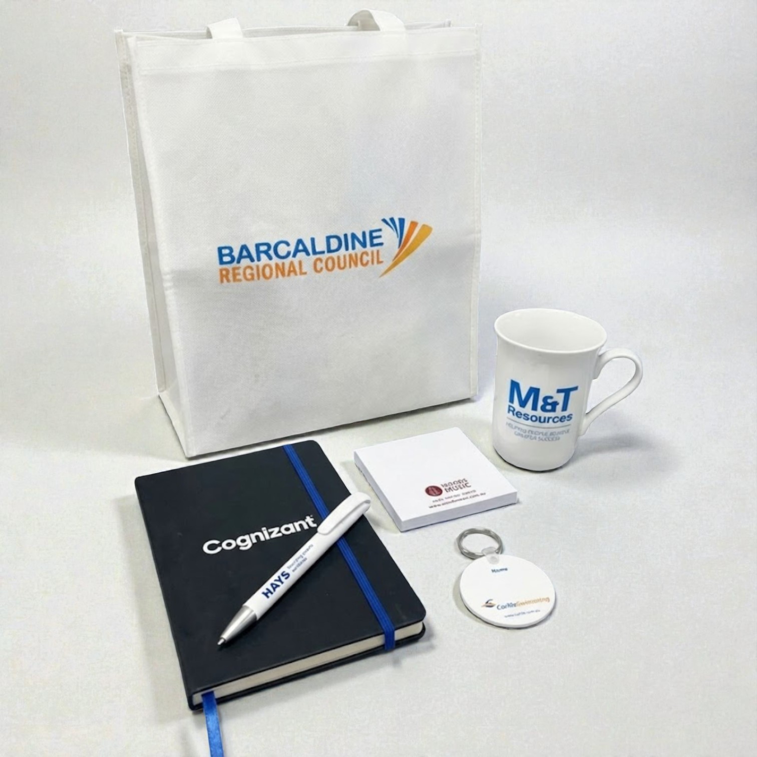 Promotional Items for Real Estate Welcome Packs: tote bag, mug, notebook, and more on white background.