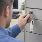 Man unlocking a gray filing cabinet with Arteo Tyre Tread Key Rings in an office.