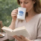 Woman reading a book, sipping from a Bone China Coloured Mug.