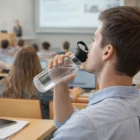 Student using Bpa Free Coloured Bottles in a classroom during a lecture.