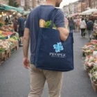 Man carrying The Large Diamond Tote Bag with People logo at an outdoor market.