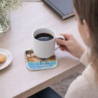 Woman holding a mug on Premium Everyday Coasters, with cookies, flowers, and a book nearby.