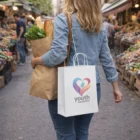 Woman carrying groceries in Vex Paper Carry Bags Large at an outdoor market.
