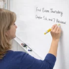 Woman writing exam review on a whiteboard with Muxi Multifunction Pens.