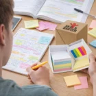 Person uses Cubex Desk Sets and colorful sticky notes; Skills Barter box is open.