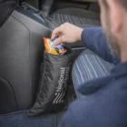Person puts snacks in a Capex Car Rubbish Bag attached to the seat.