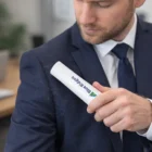 A man in a suit uses Travel Lint Rollers to remove hair from his jacket.