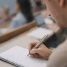 Person taking notes in class with an Artella Pens Colour Match on the desk.