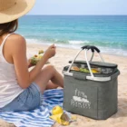 Woman enjoys salad on the beach with a Frosty Cooler Picnic Basket featuring EcoCity logo.