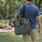 A man with a Polar Premium Branded Chiller Bag approaches a family enjoying a picnic on the grass.