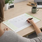 Person planning their week with coffee using a Personalised A2 Desk Blotter Calendar.