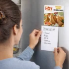 Woman places a shopping list on the fridge using a Square Fridge Magnet 7Cm above it.