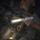 Man using Fluro Magnetic Cob Lights to inspect a car engine at night.