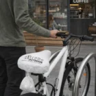 Person with a white bike using Waterproof Bike Seat Covers near an outdoor café.