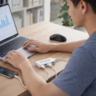 Person uses Tech Usb Hubs to connect multiple devices to a laptop on a desk.