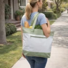 Woman walks with groceries in a leafy area, carrying a Berrien Custom Decorated Tote Bag.