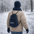 Person in Tribe Embroidered Polar Fleece Winter Set walking in snowy park with backpack.